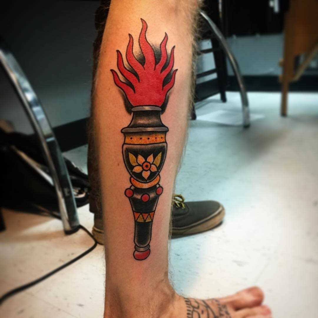 Tatuagem da tocha sobre a perna de um cara