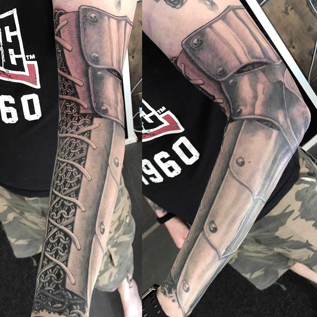 Tatuagem de armaduras na mão de um cara