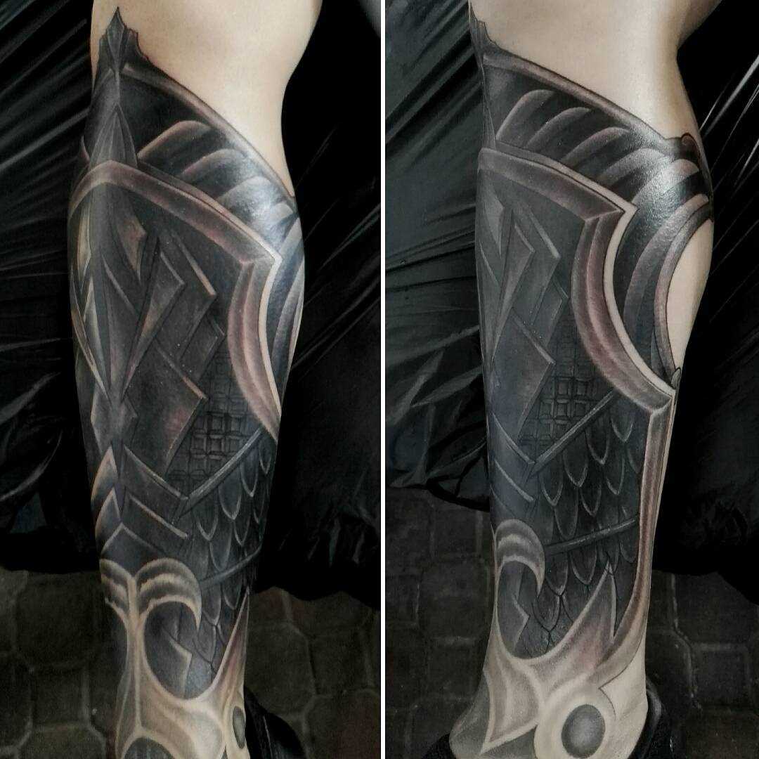 Tatuagem de armaduras sobre a perna de um cara