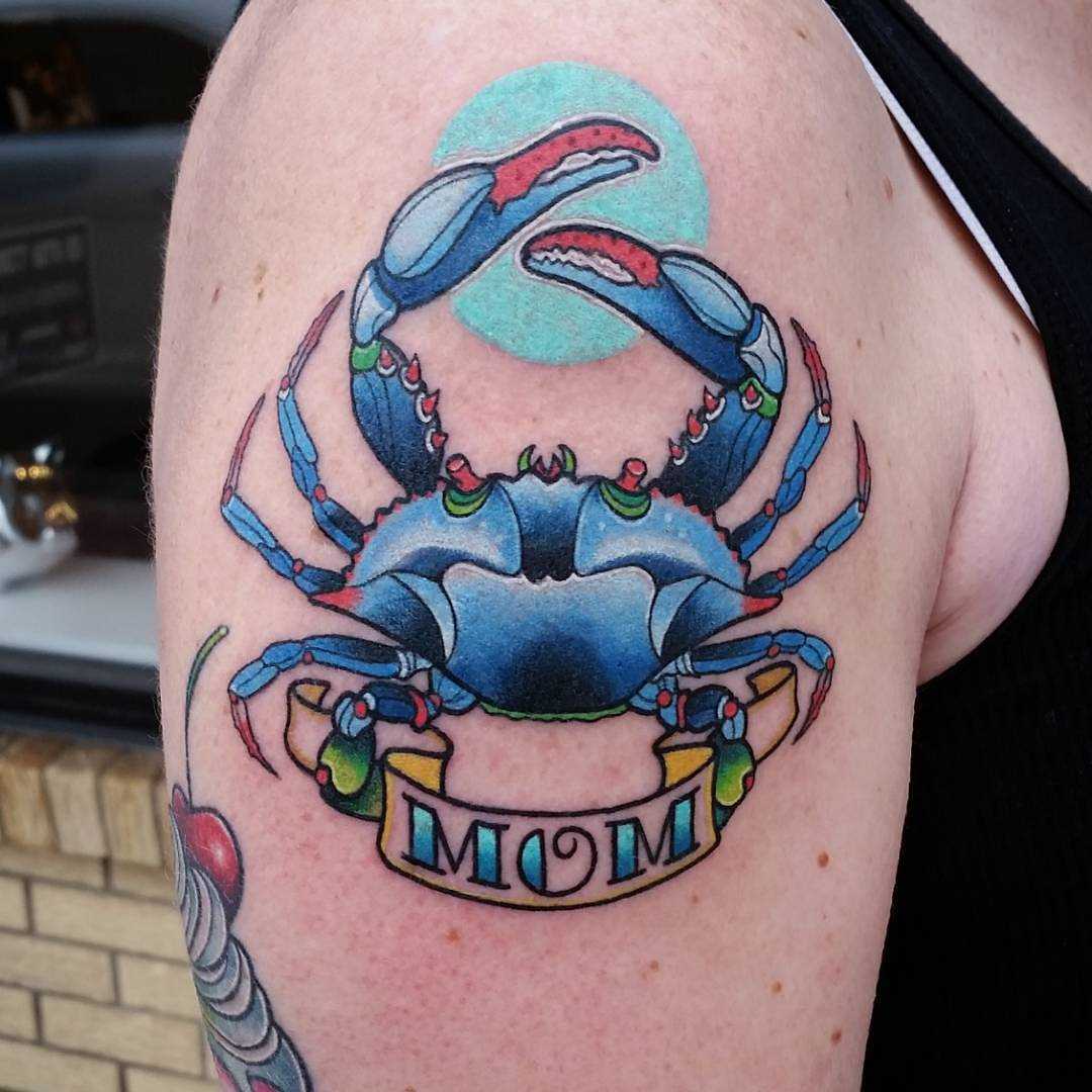 Tatuagem de caranguejo com a inscrição no ombro da menina