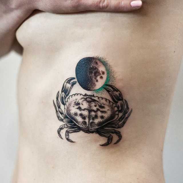 Tatuagem de caranguejo com a lua sobre as costelas menina