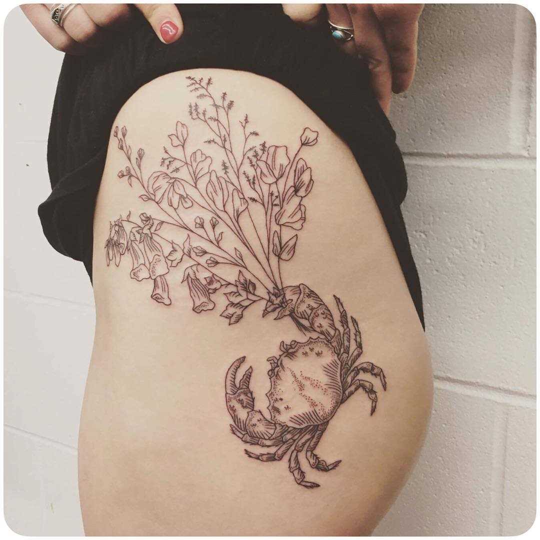 Tatuagem de caranguejo com flores no quadril da menina