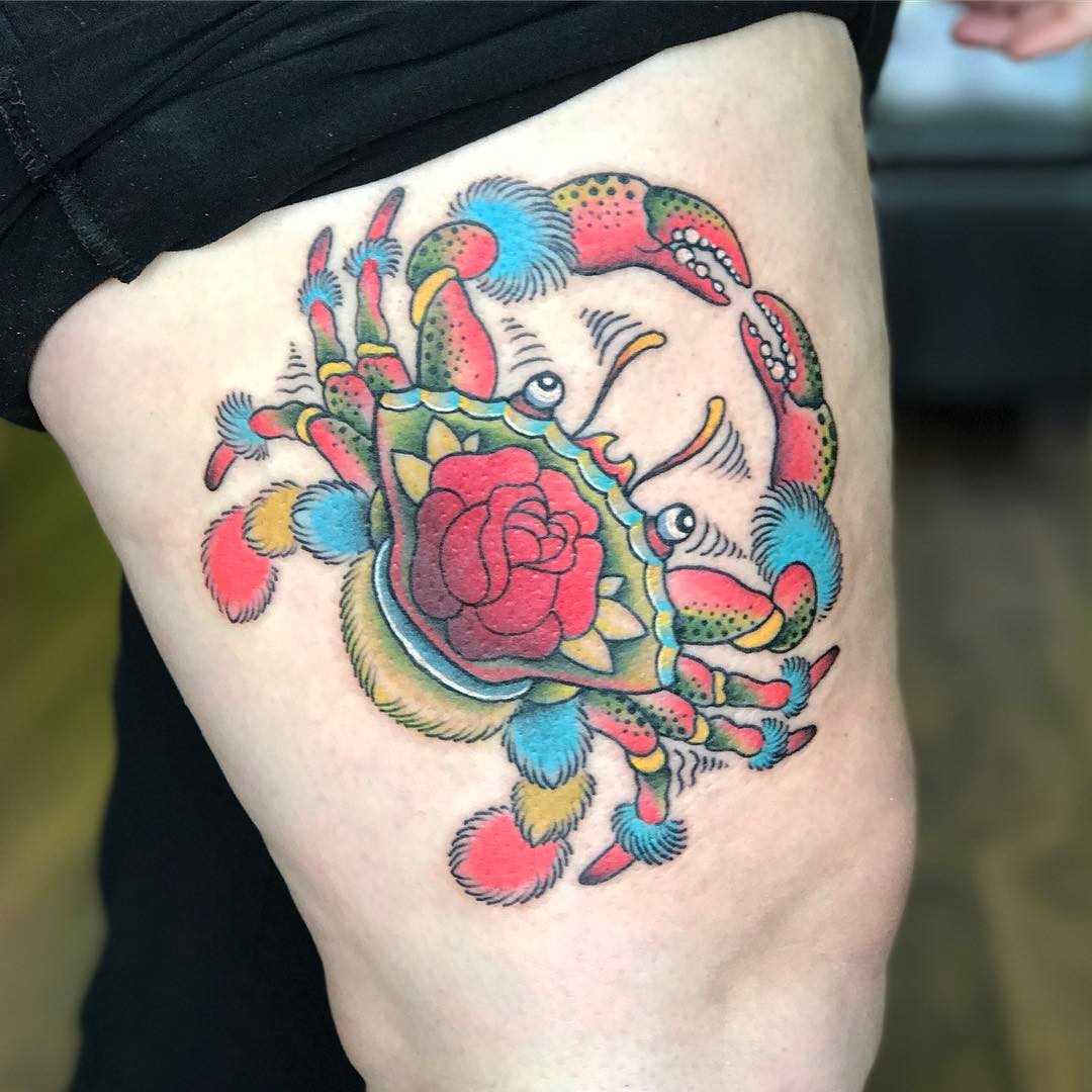 Tatuagem de caranguejo com uma rosa na coxa da menina