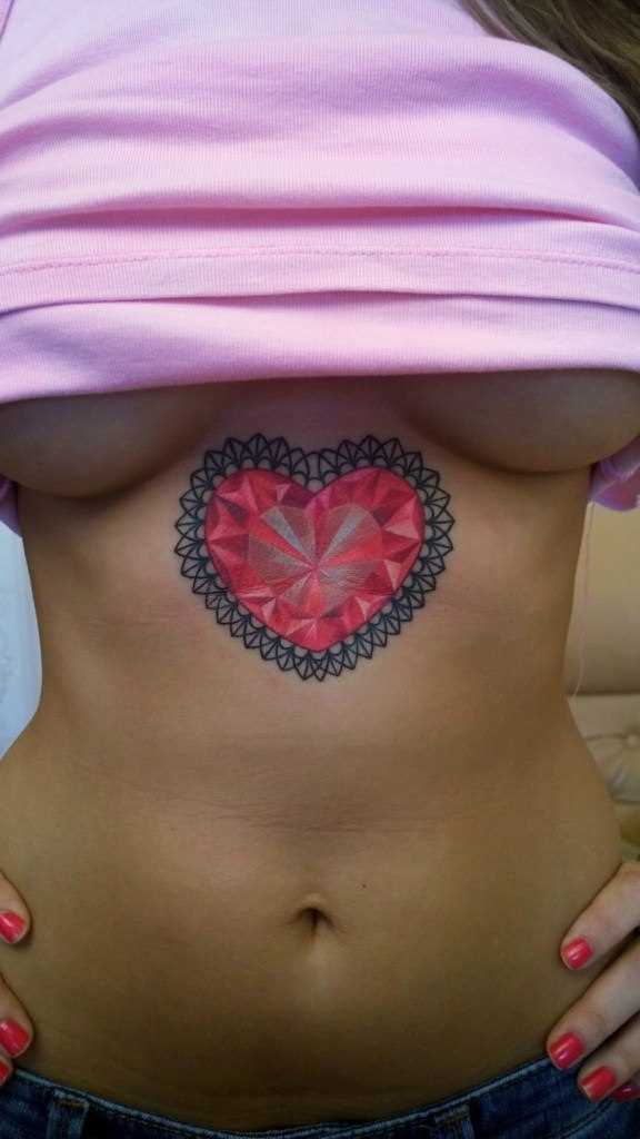 Tatuagem de coração no lado da menina junto com o peito