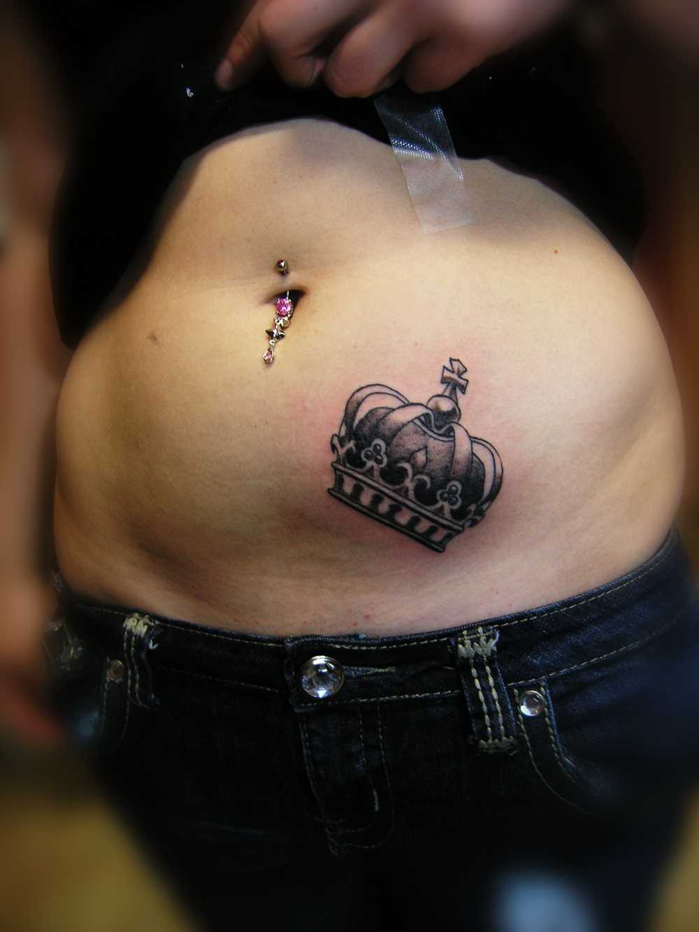Tatuagem de coroa na barriga da menina
