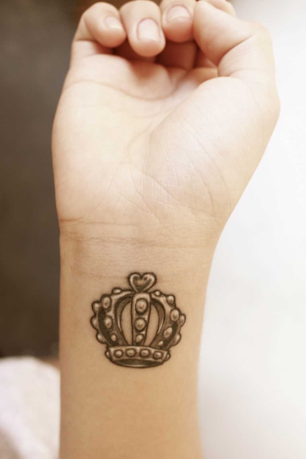 Tatuagem de Coroa no pulso da menina