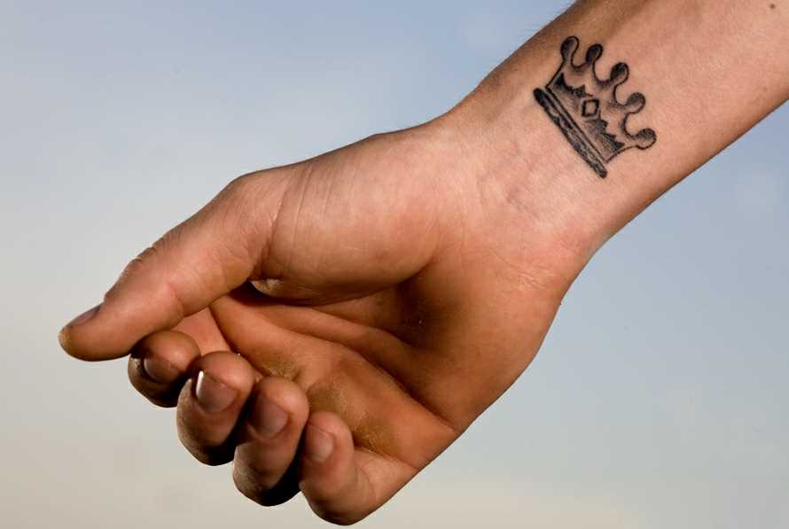 Tatuagem de coroa no pulso de um homem