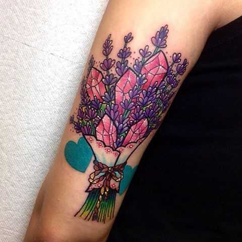 Tatuagem de cristais em um buquê de flores na mão de uma mulher