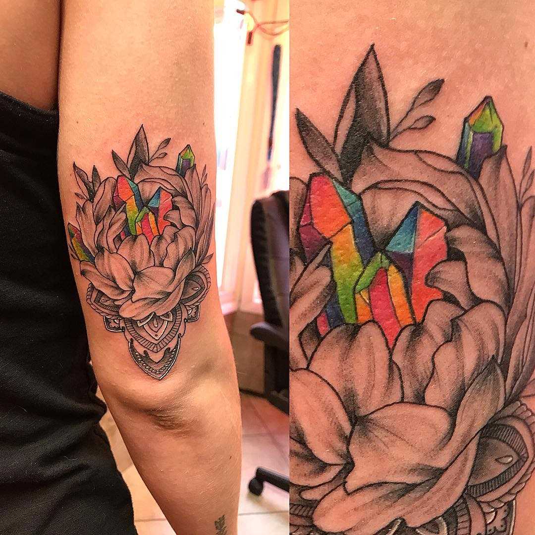 Tatuagem de cristais em uma flor na mão de uma menina