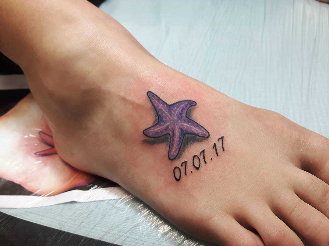 Tatuagem de estrela do mar com a inscrição na planta do pé da menina