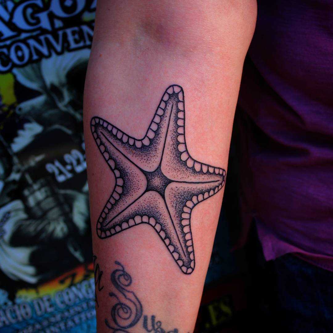 Tatuagem de estrela no antebraço da mulher