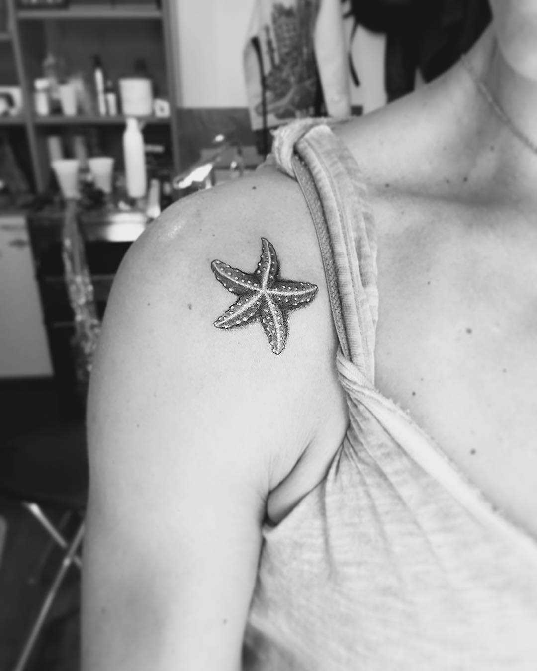 Tatuagem de estrela no ombro da mulher