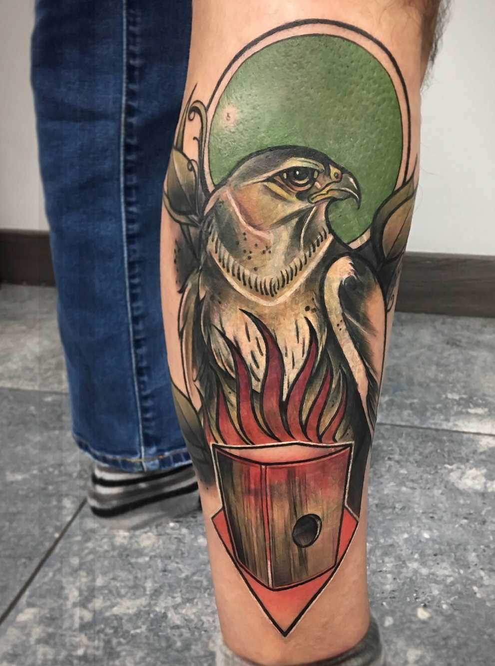 Tatuagem de falcão sobre a perna de um cara