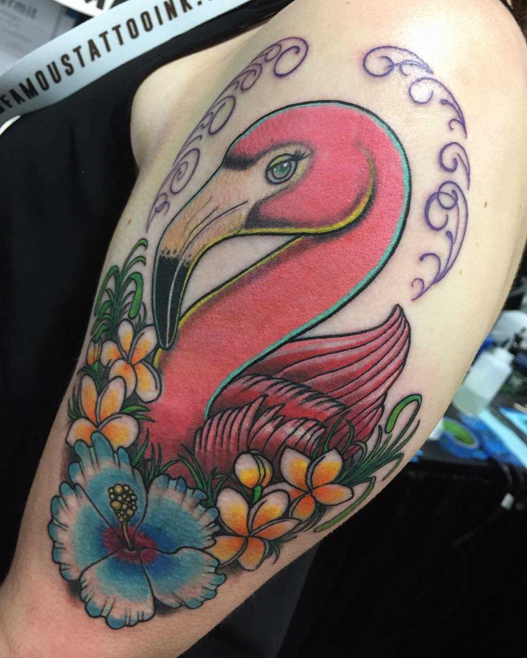 Tatuagem de flamingos com flores no ombro da mulher