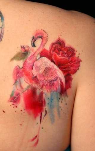Tatuagem de flamingos com uma rosa na lâmina de uma mulher