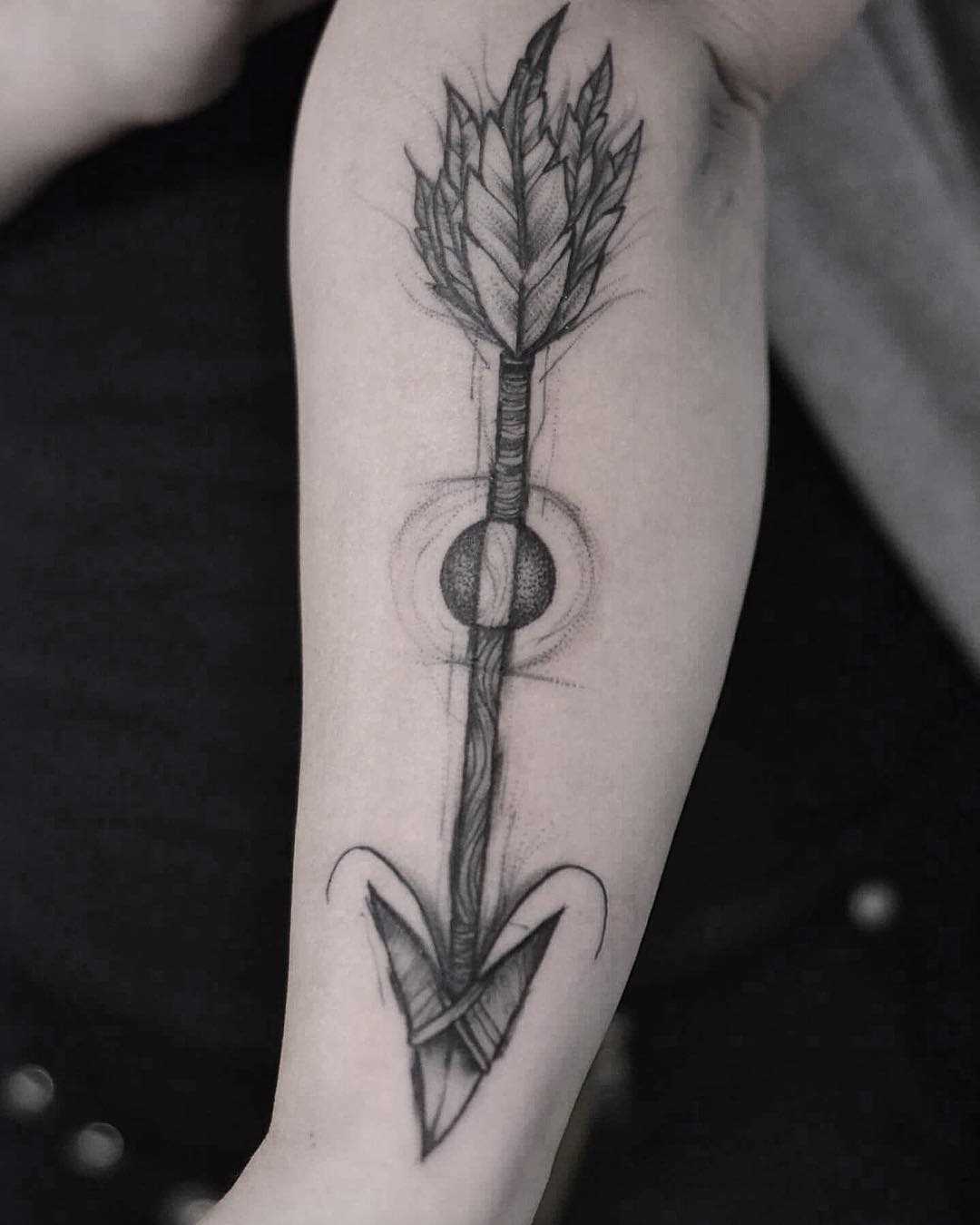 Tatuagem de flechas sobre a perna da mulher