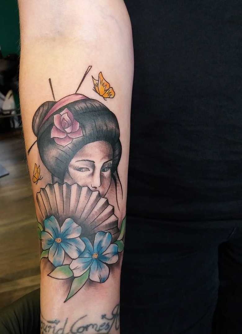 Tatuagem de gueixa com flores no antebraço cara
