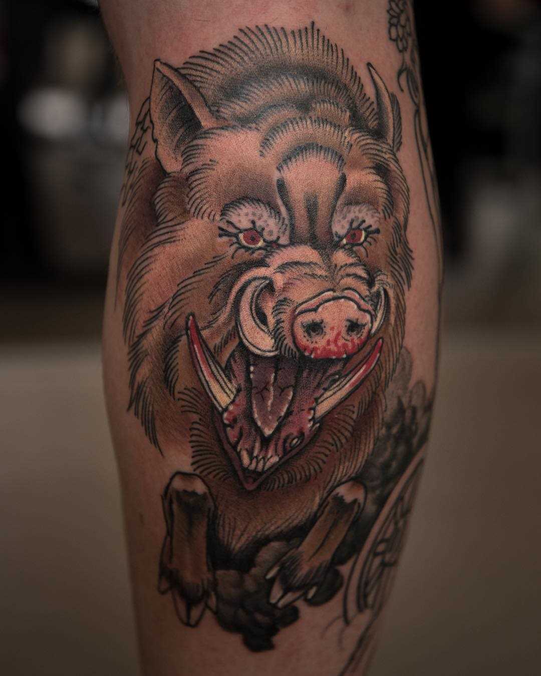 Tatuagem de javali sobre a perna de um cara