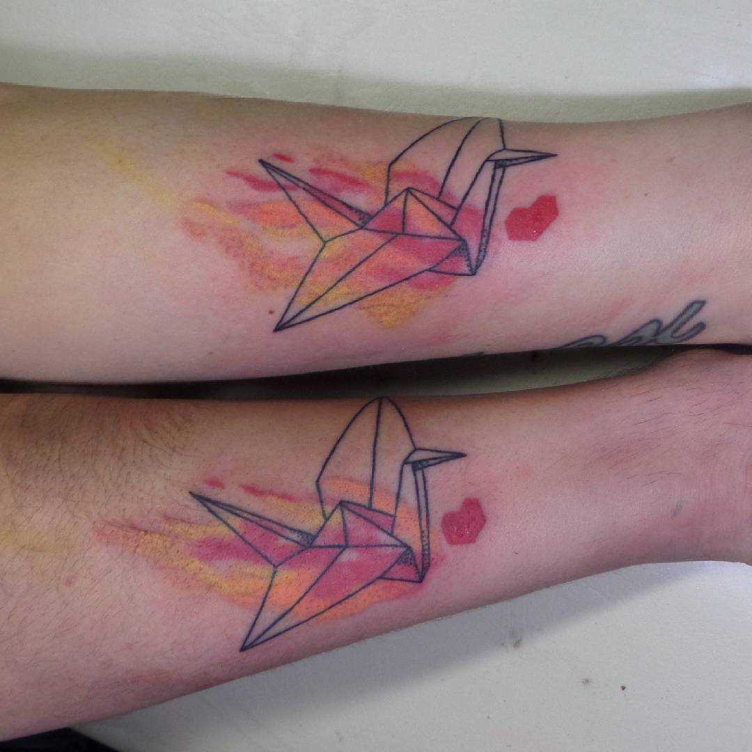 Tatuagem de origami-guindaste sobre a perna de uma menina e um cara