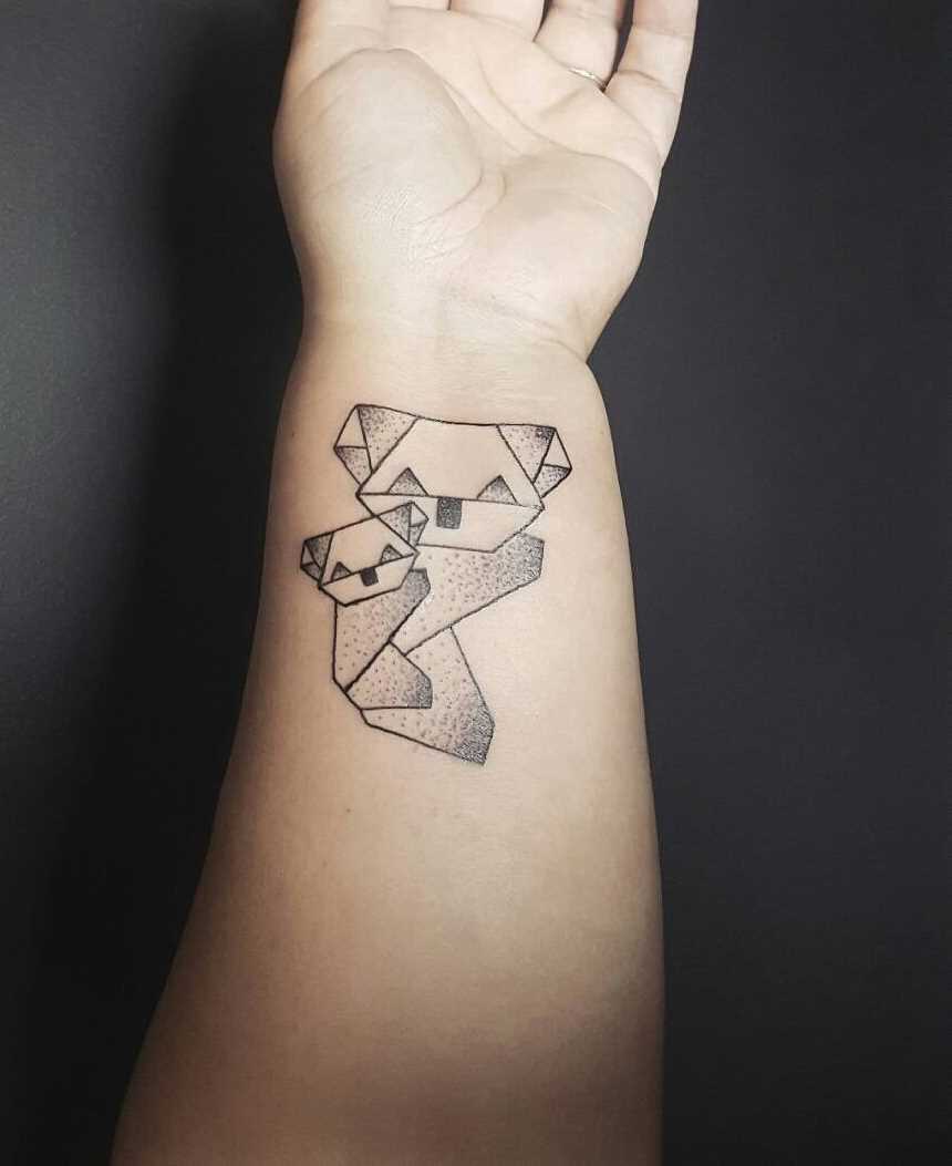 Tatuagem de origami-pandas no pulso da menina