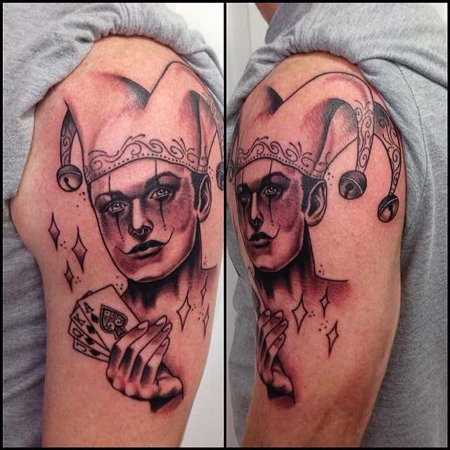 Tatuagem de palhaço com cartões no ombro do cara