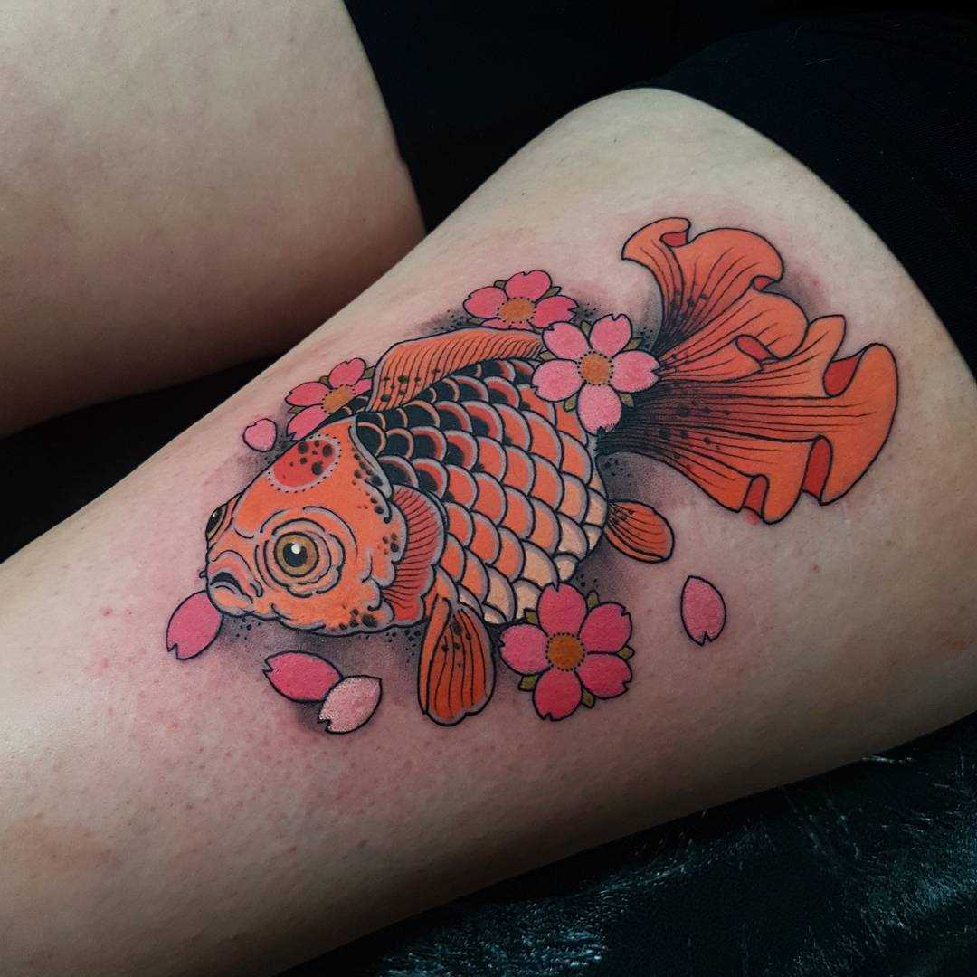 Tatuagem de peixe de ouro com flores no quadril da menina