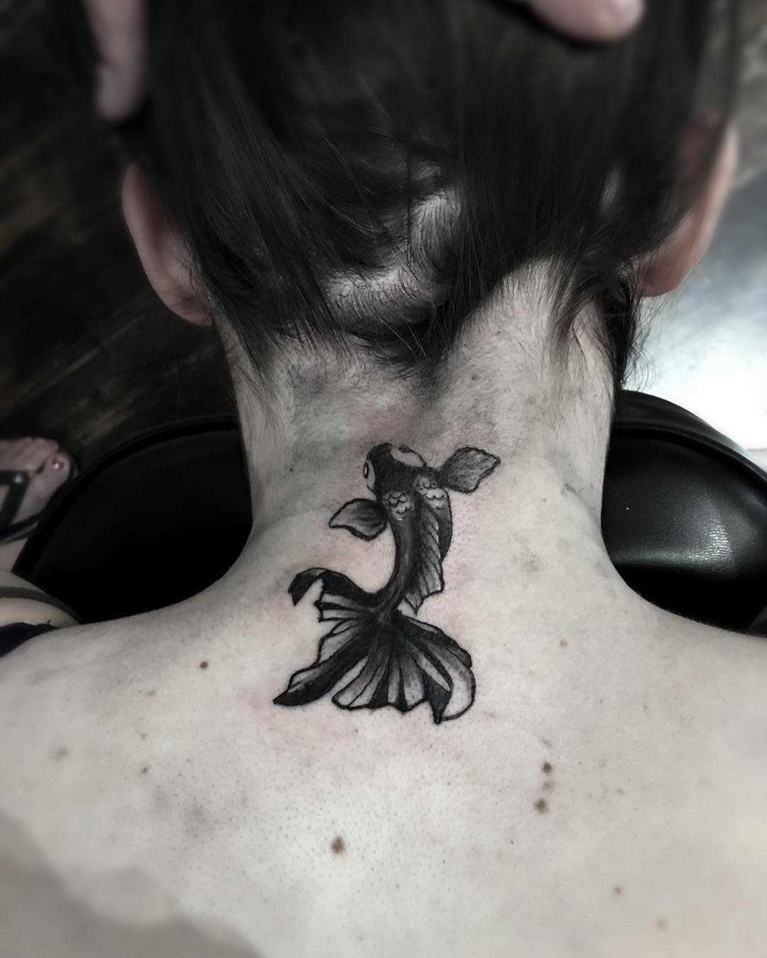 Tatuagem de peixe de ouro em volta do pescoço da menina