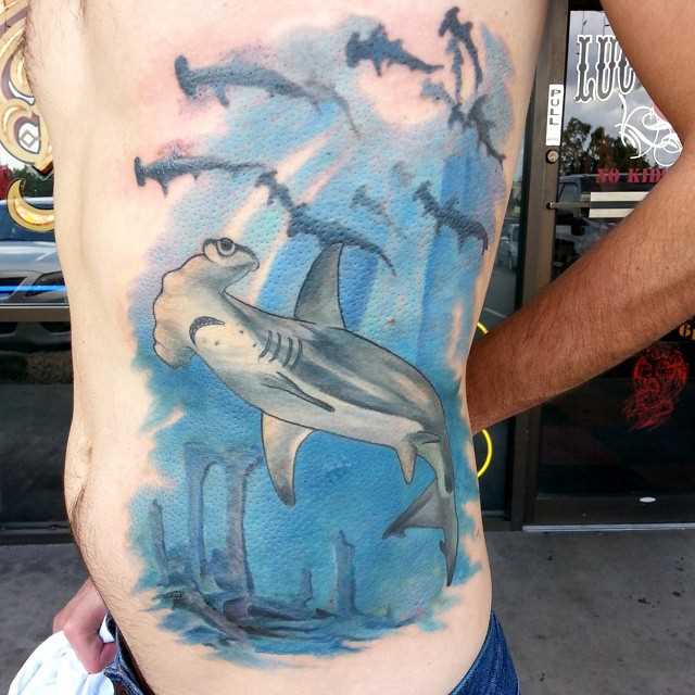 Tatuagem de peixe-martelo ao lado de um cara
