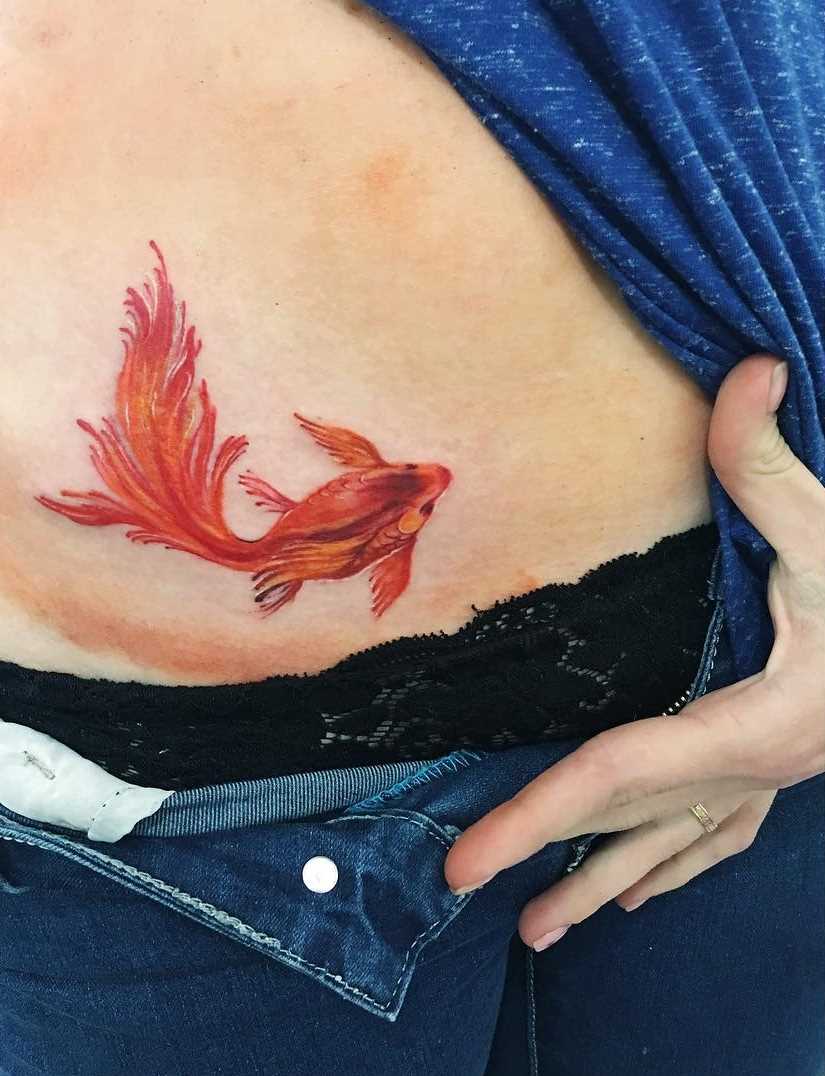 Tatuagem de peixinho na barriga da menina