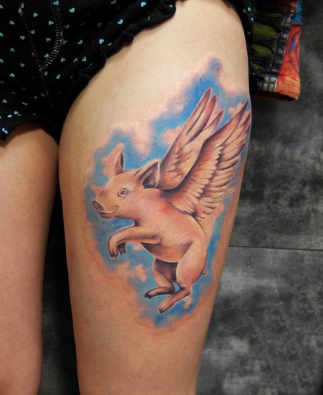 Tatuagem de porco com asas no quadril da menina