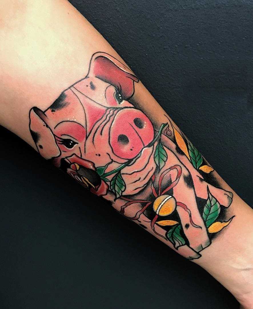Tatuagem de porco com uma rosa no antebraço da menina