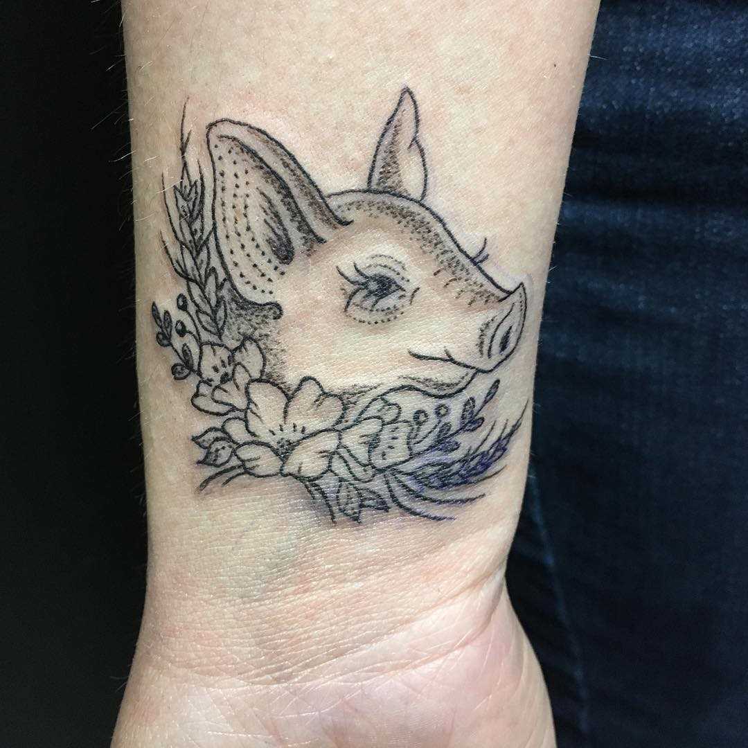 Tatuagem de porco no pulso da menina