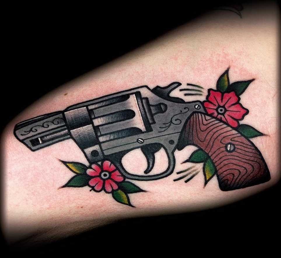 Tatuagem de revólver na mão de homens