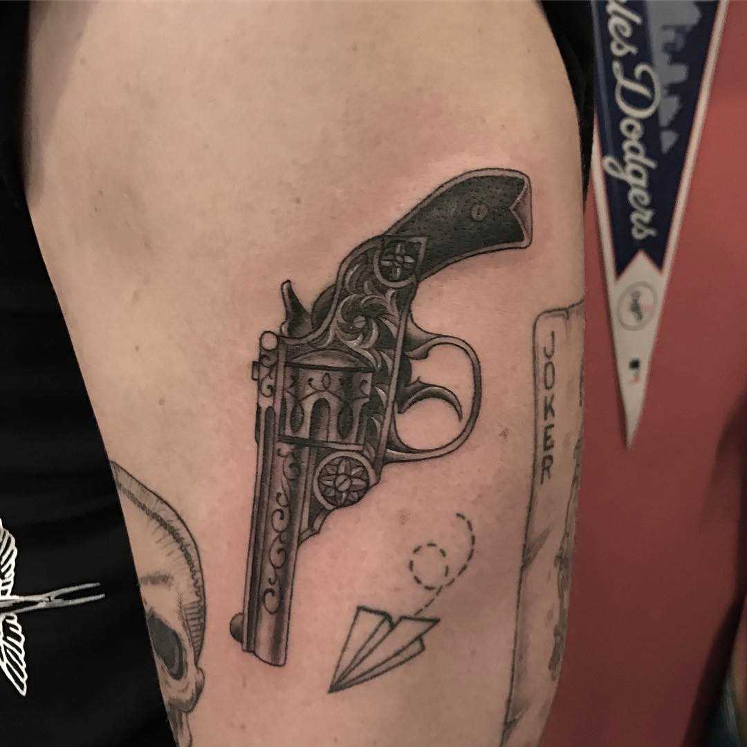 Tatuagem de revólver no quadril da mulher