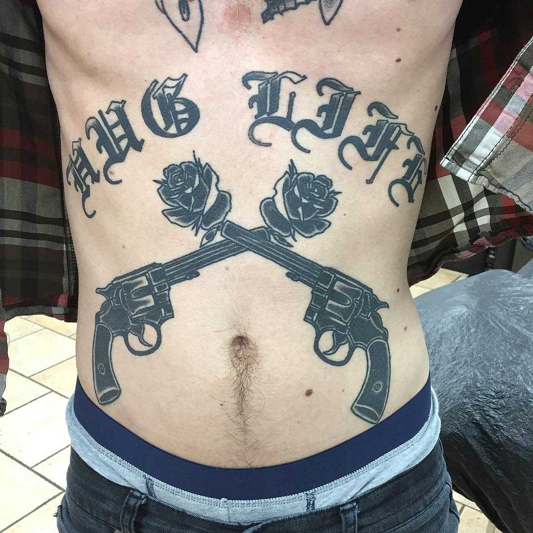 Tatuagem de revólveres com rosas na barriga homens