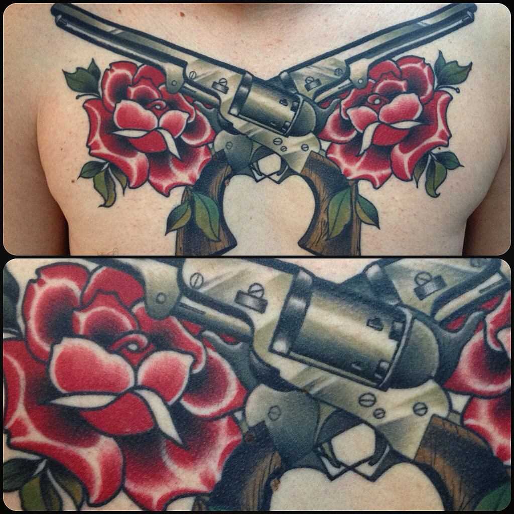Tatuagem de revólveres com rosas no peito do cara