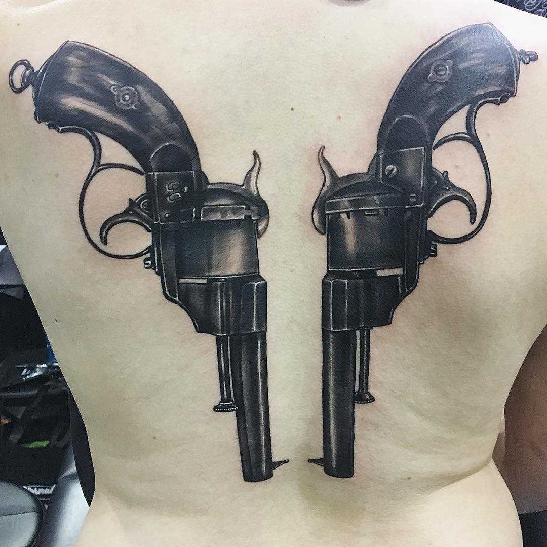 Tatuagem de revólveres nas costas de homens