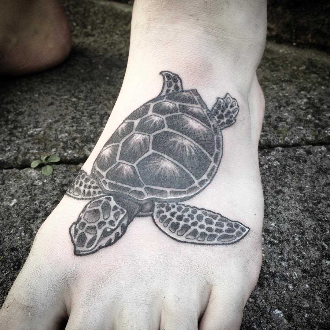 Tatuagem de tartaruga na planta do pé do cara