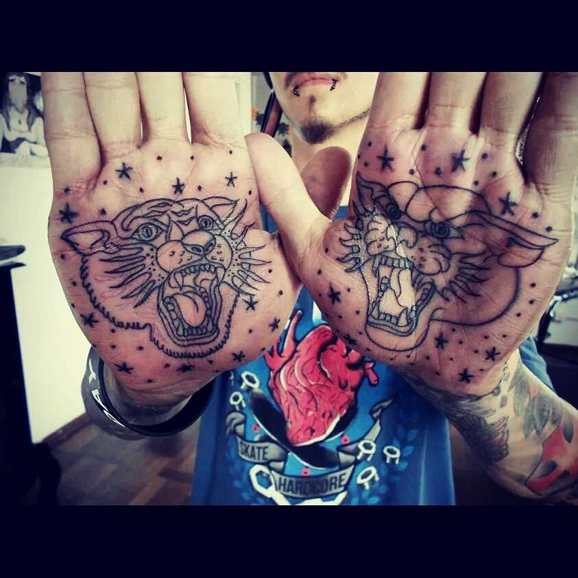 Tatuagem de tinta preta nas mãos de um cara em estilo oldschool - o tigre e a pantera