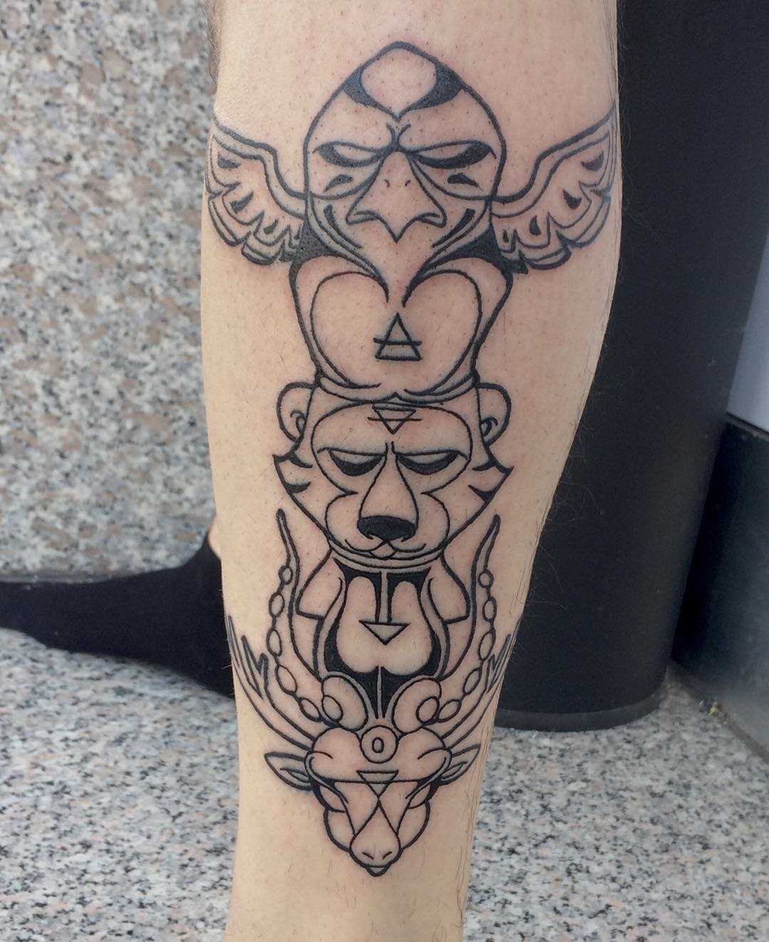 Tatuagem de totem animal sobre a perna de um cara
