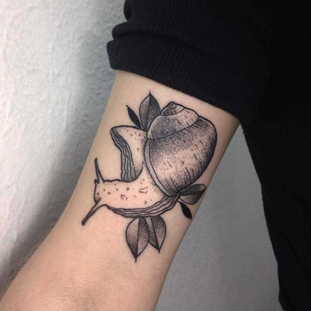 Tatuagem de um caracol na mão de um cara