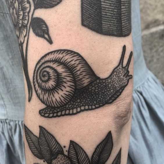 Tatuagem de um caracol no cotovelo menina