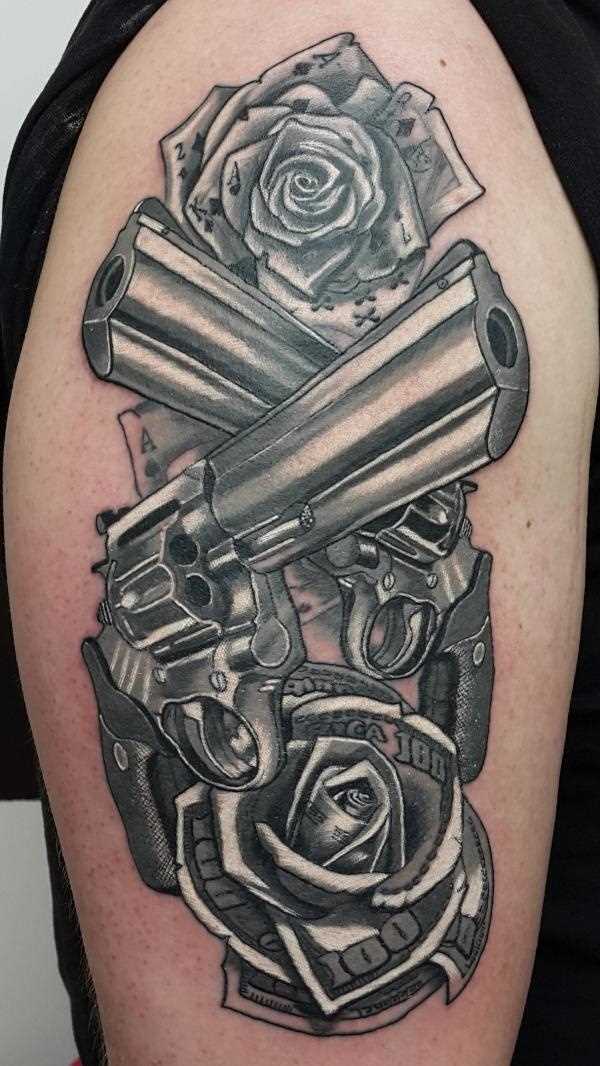 Tatuagem de um cartão de dinheiro duas metralhadoras no ombro de homens