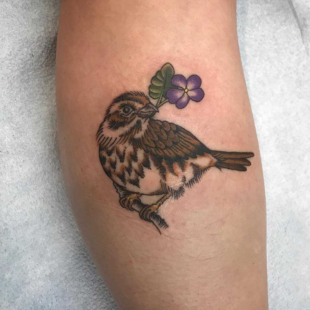 Tatuagem de um pardal sobre a perna da mulher