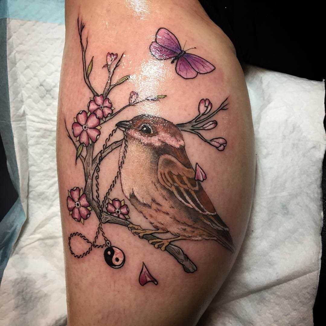 Tatuagem de um pardal sobre a perna de um cara