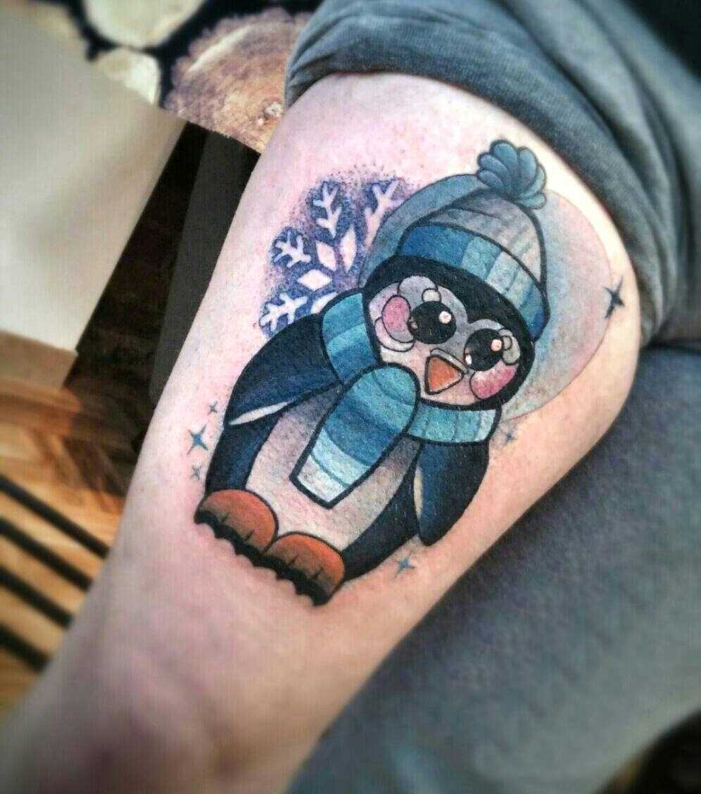 Tatuagem de um pinguim sobre a coxa da menina