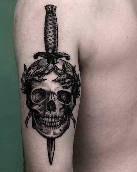 Tatuagem adaga com um crânio na mão de homens