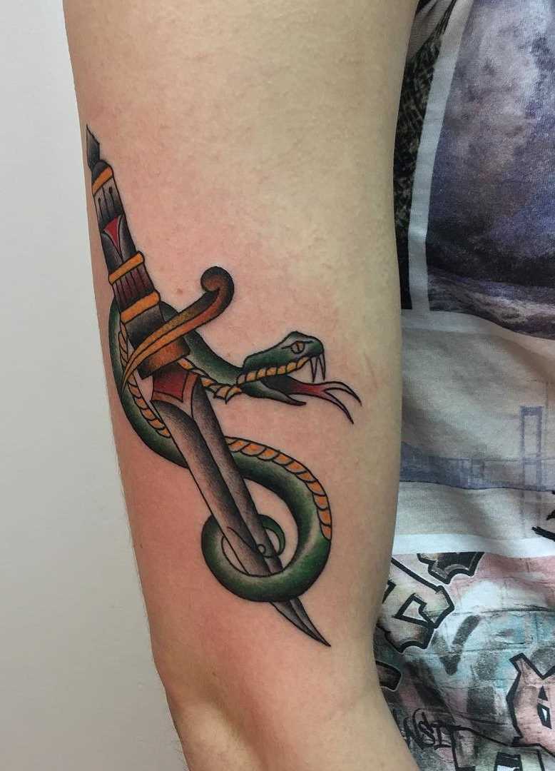 Tatuagem adaga com uma cobra na mão de homens