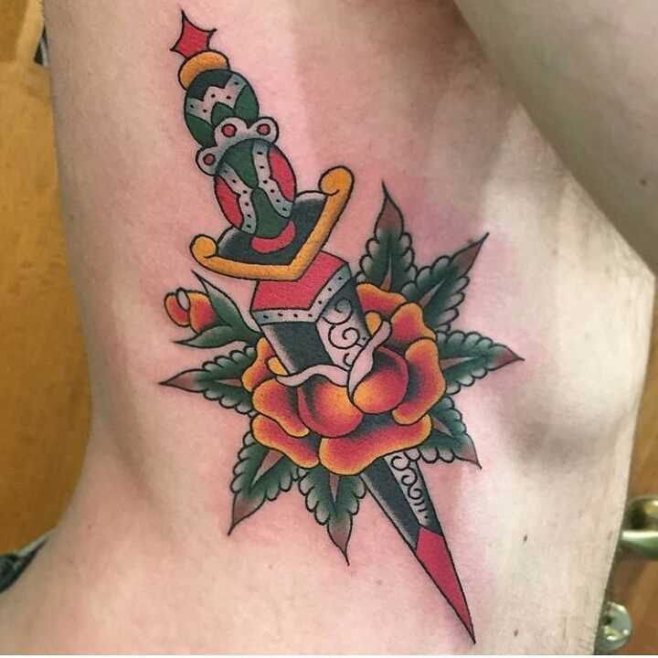 Tatuagem punhal com uma rosa ao lado de um cara