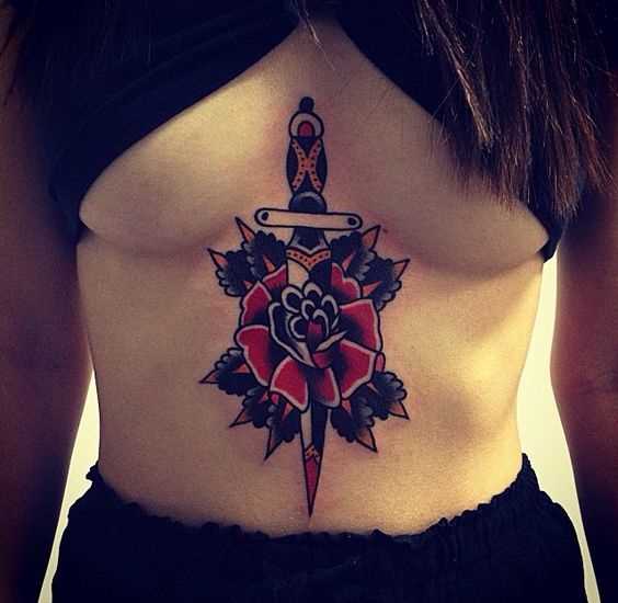 Tatuagem adaga com uma rosa na barriga da menina